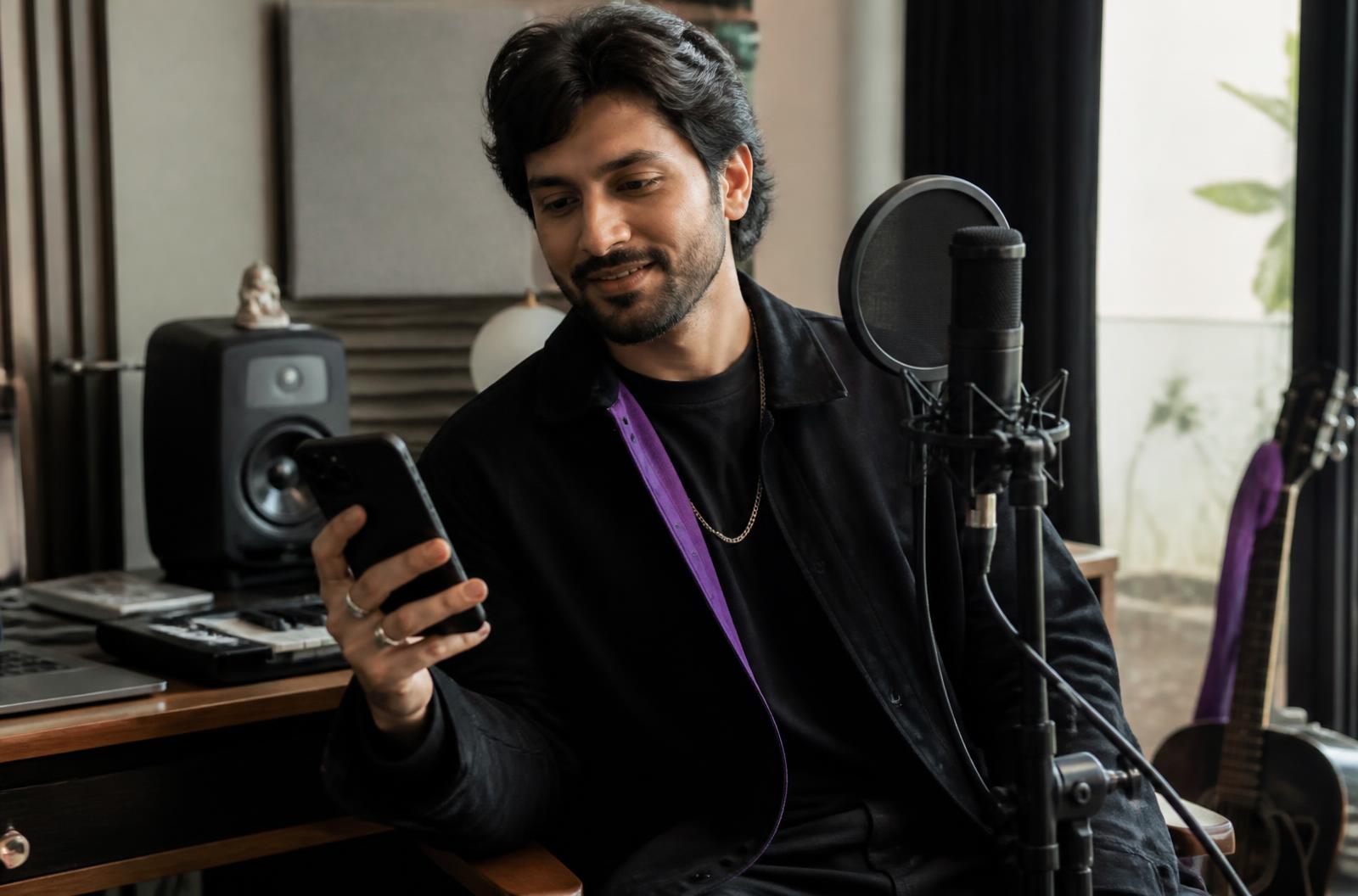 Indian musician reviewing audience messages in his home studio
